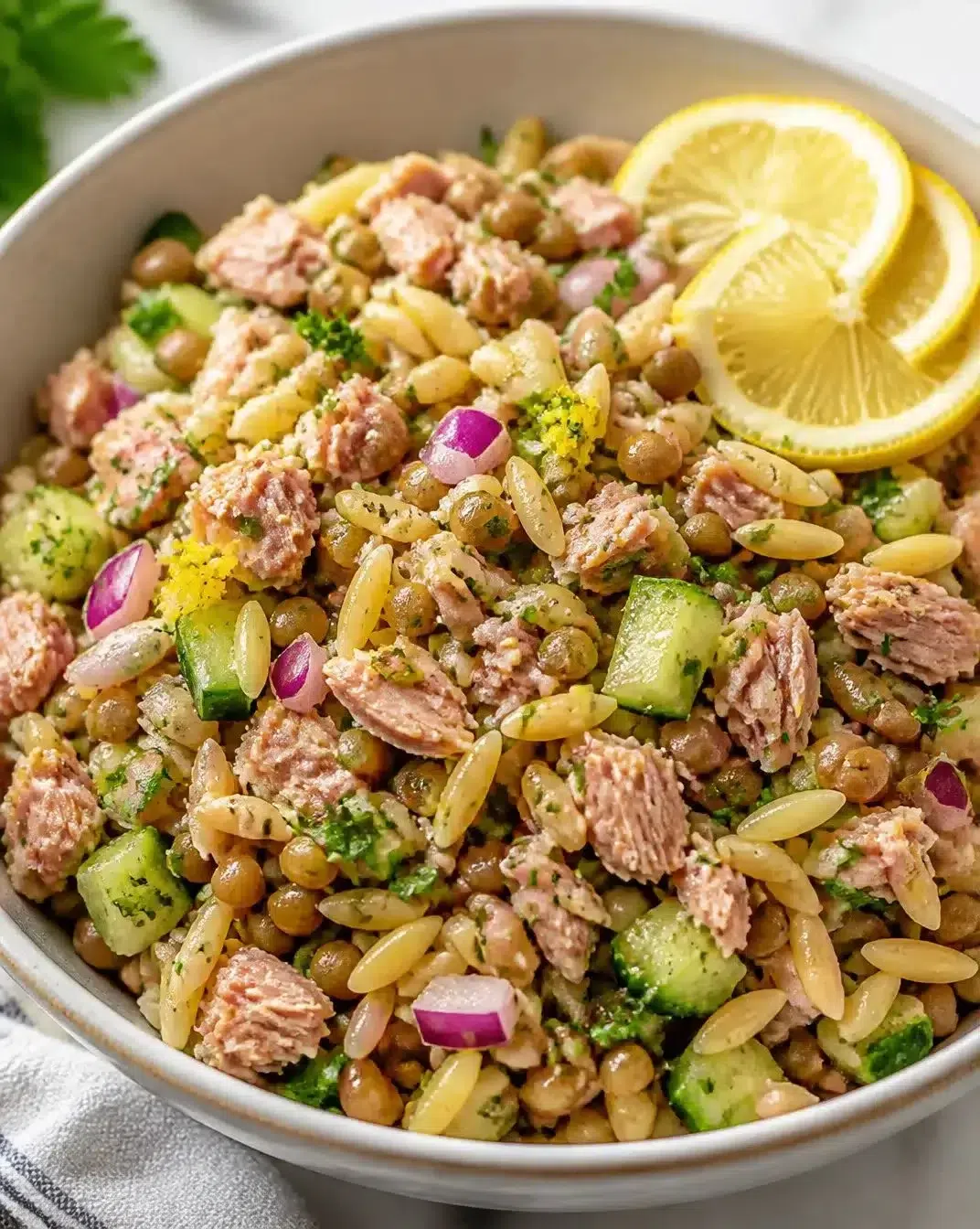 Lemon-infused tuna, lentil, and orzo salad in a bowl.