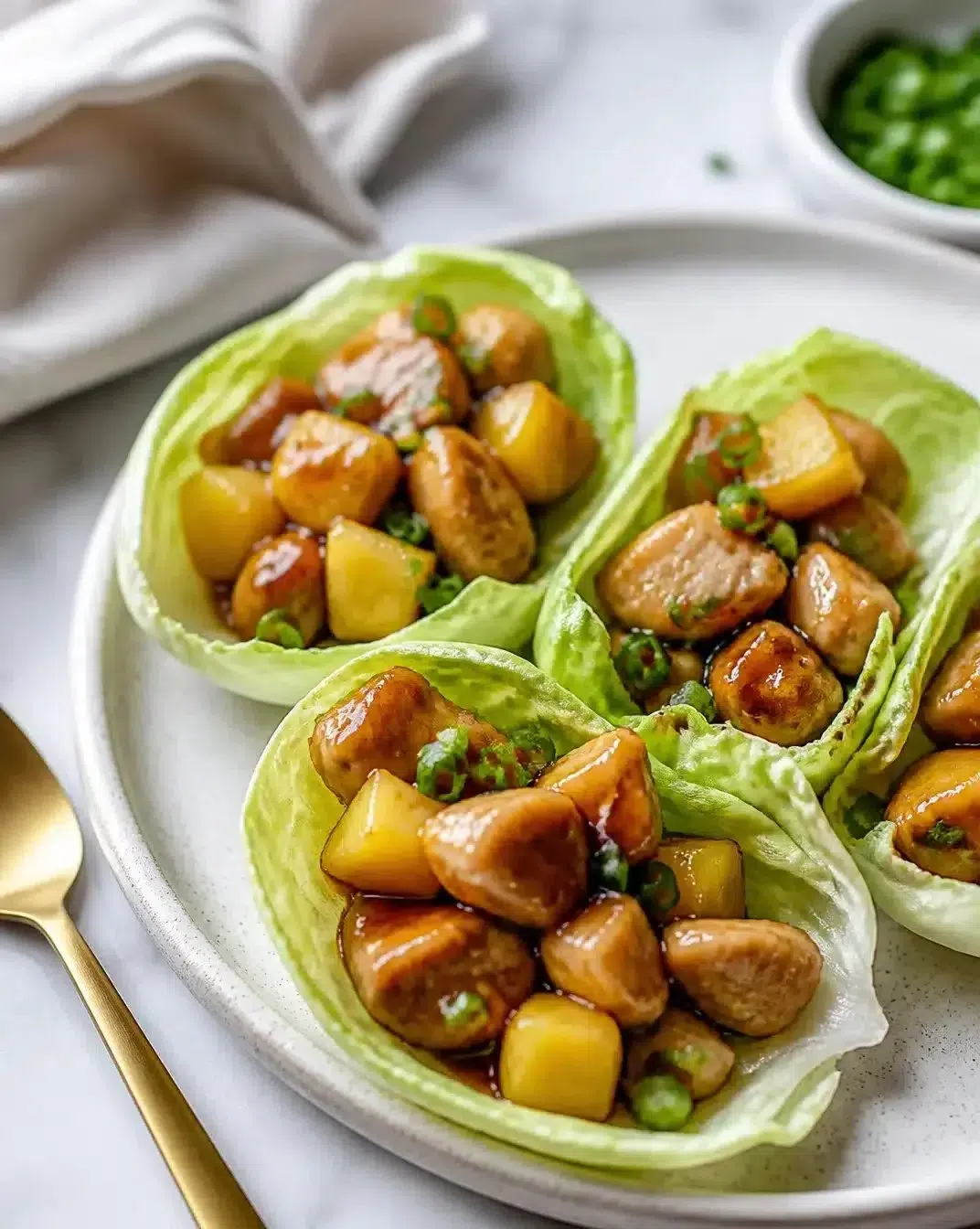 Whiskey-glazed chicken lettuce wraps served on a plate
